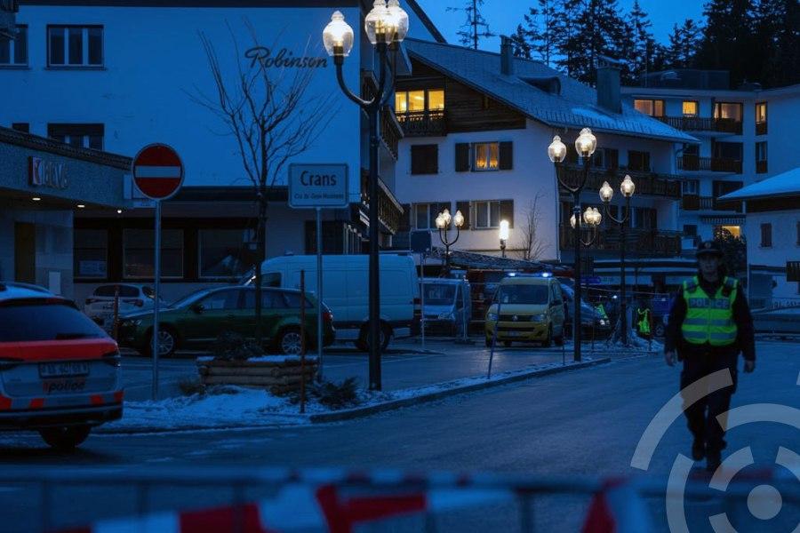 В четверг в городе Кранс-Монтана полицейский идет рядом с машинами скорой помощи на месте пожара в баре.